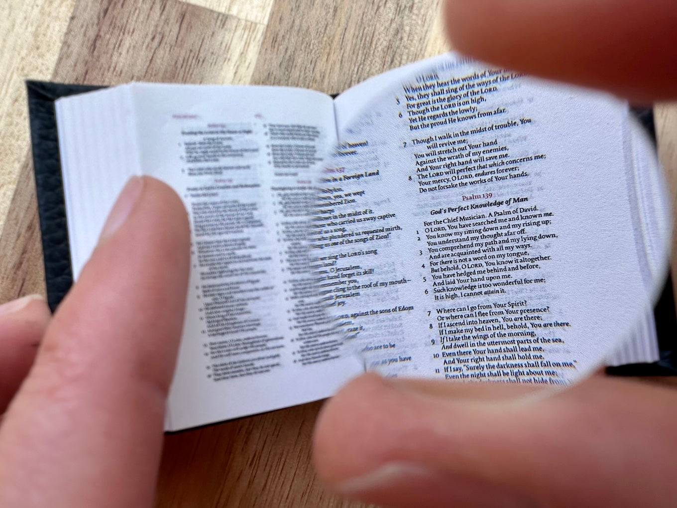 NKJV Tiny Bible open with glass lens
